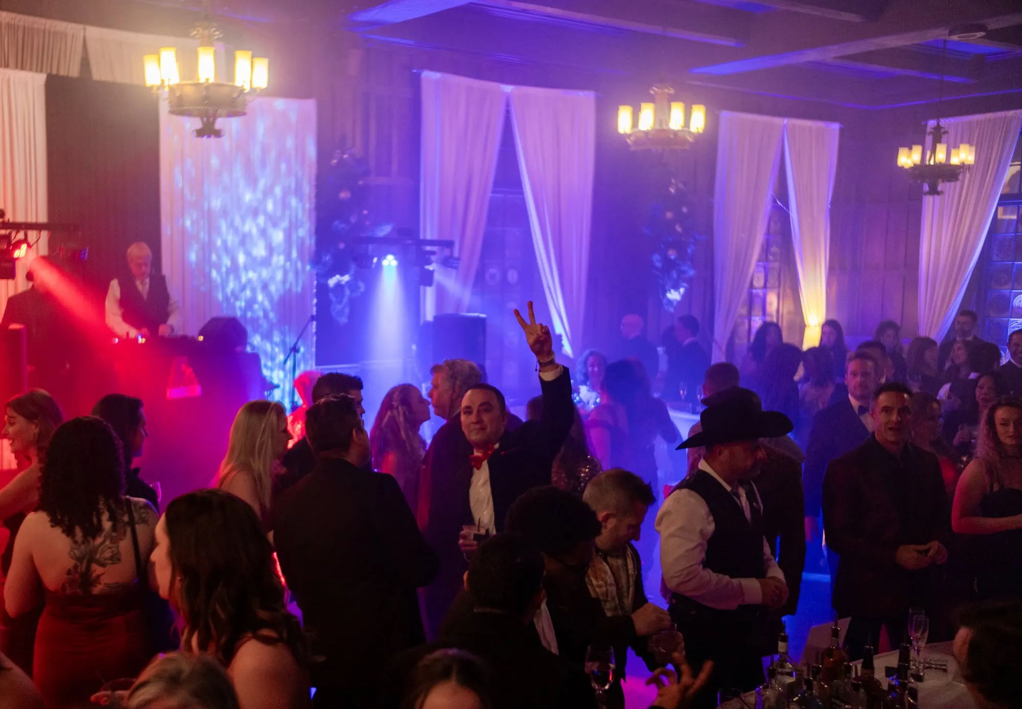Black-tie guests fill the dance floor under stage lighting at the Denver Winter Ball